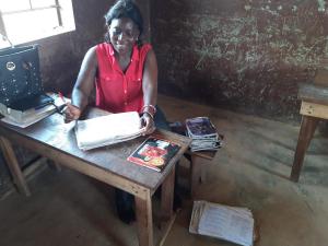 Teacher marking books. Children have to buy their own books so some choose ones with their favourite footballer on!